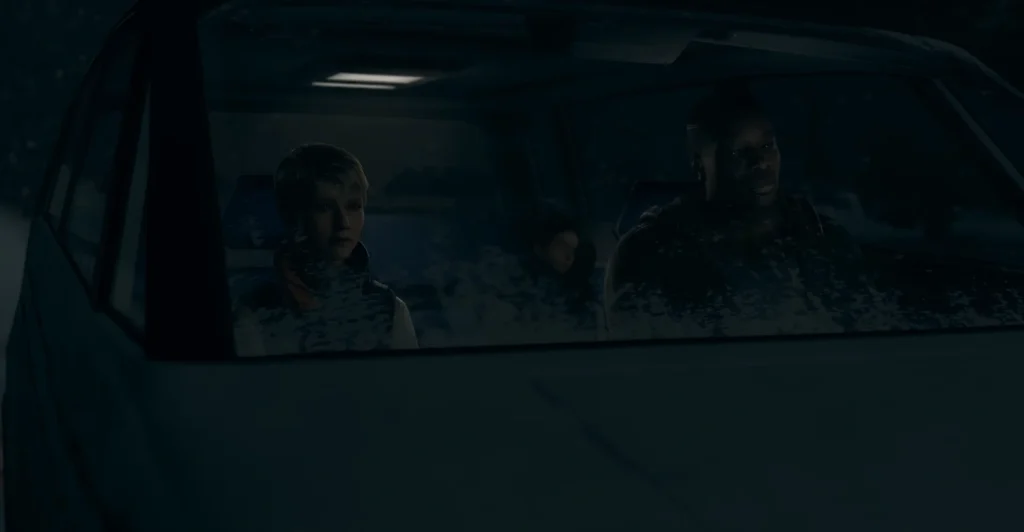 Three people sit inside car at night