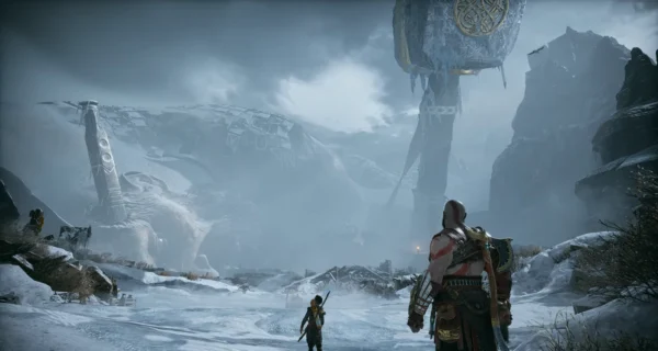 Kratos and Atreus walk through snowy ruins in God of War