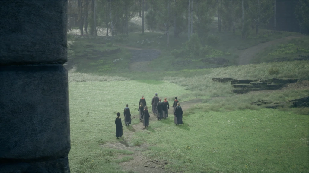 Students walking across grassy field near stone ruins