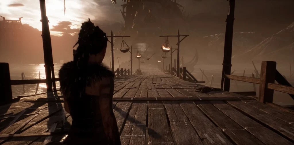 Senua walks on wooden pier toward burning braziers