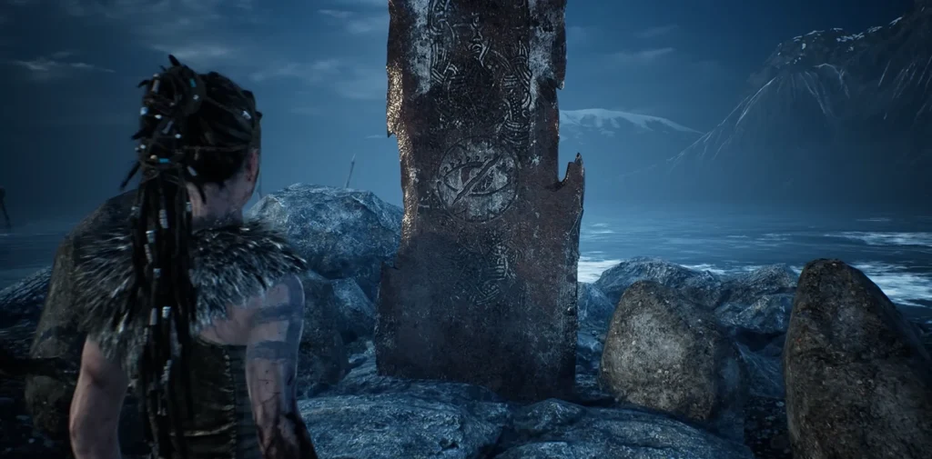 Senua from Hellblade stands by rune stone shore