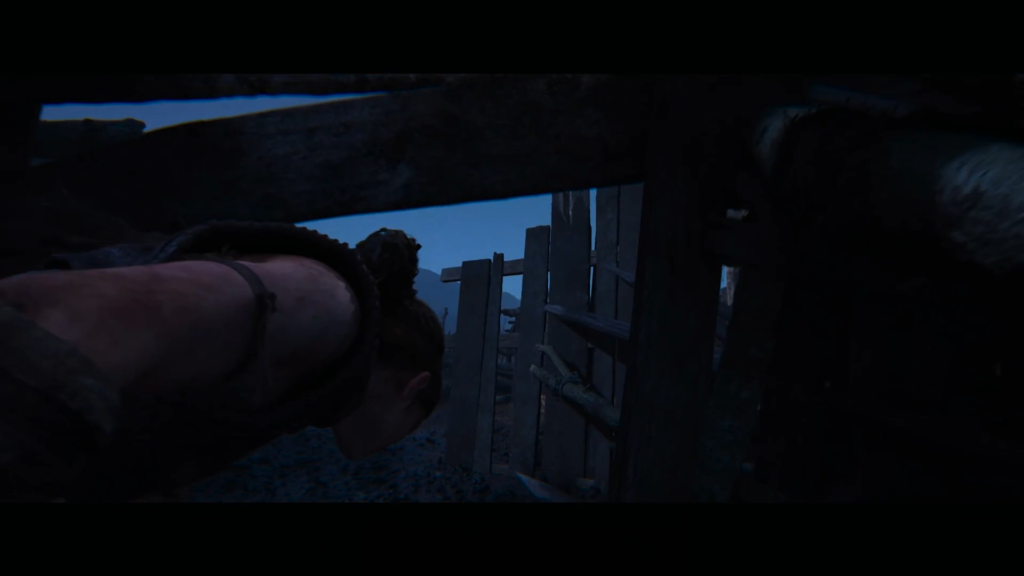 Woman crawling through wooden fence gap at night