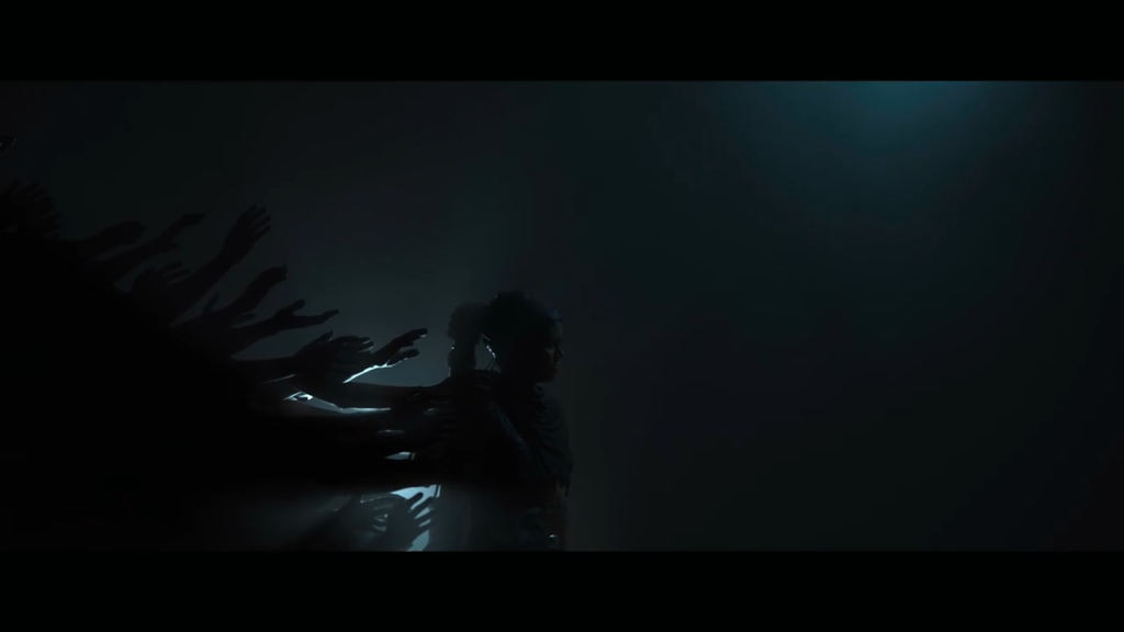 Silhouetted woman walking as shadowy hands reach behind