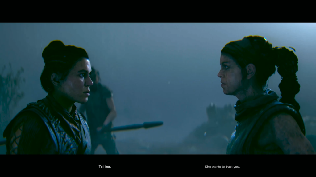 Two women face each other in foggy camp