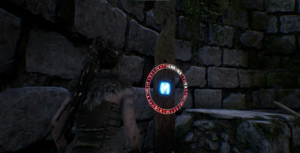 Senua examines glowing rune circle on stone wall