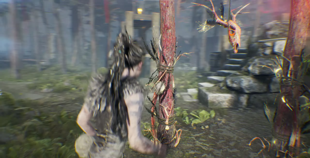 Senua walks past red totem in forest ruins