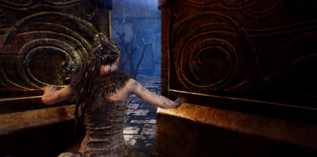 Senua opens carved doors in dark forest path