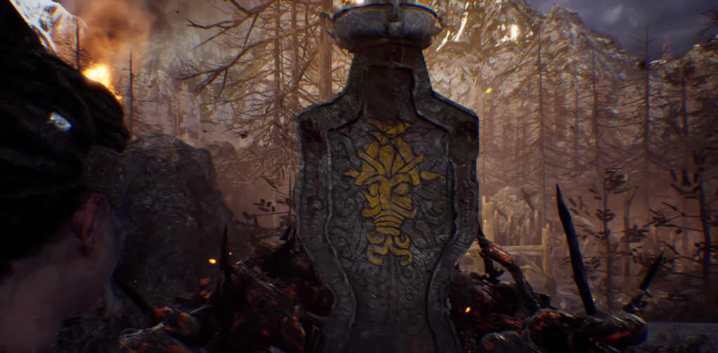 Stone monument with yellow emblem in burnt forest