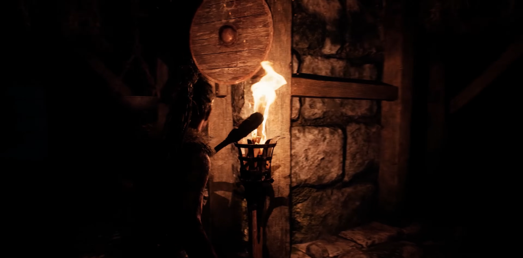 Person holding torch beside stone wall indoors