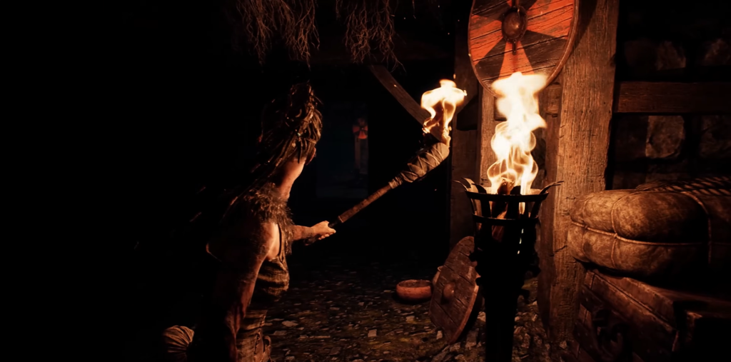 Woman holding torch inside dark wooden hut