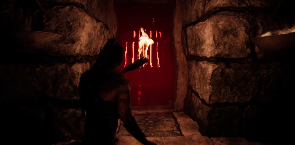 Person holding torch in stone corridor with red gate