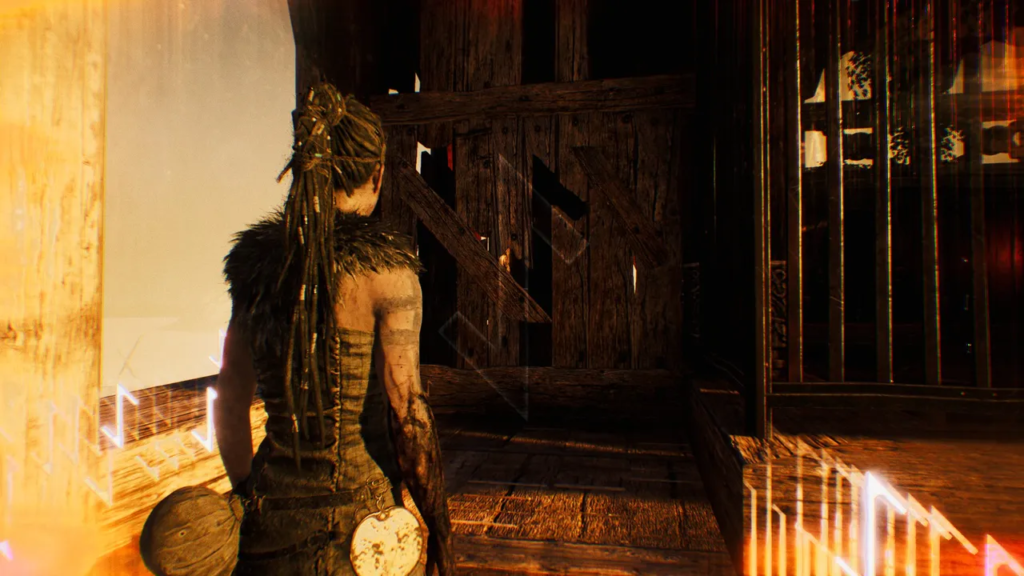 Senua stands by wooden gate in Hellblade: Senua's Sacrifice