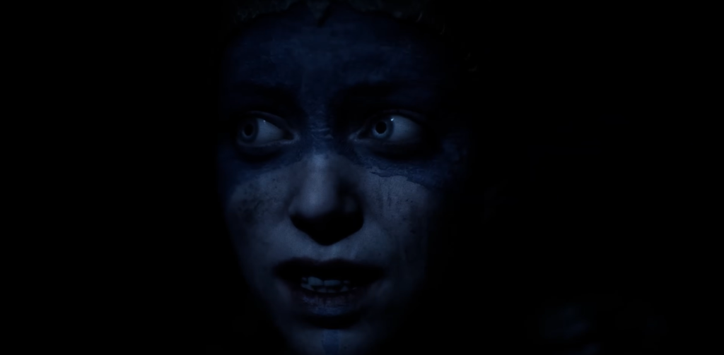 Синее лицо человека смотрит вверх в темноте