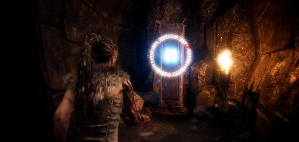 Senua approaches glowing portal in Hellblade cave