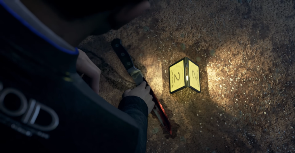 Hand holding knife near evidence marker on dirt