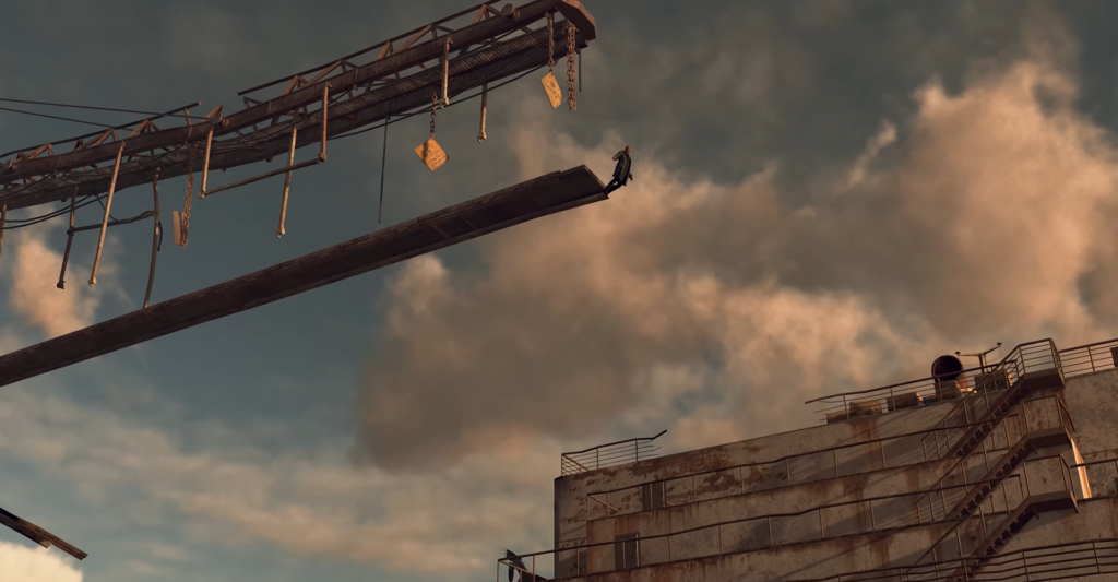 Person standing on crane beam above industrial building