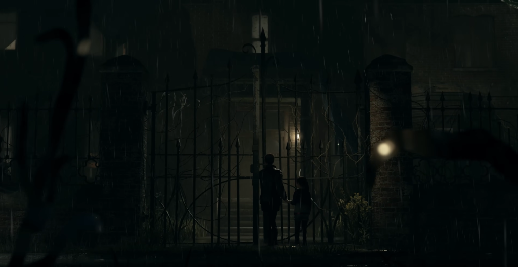 Two people standing at gate in rain at night