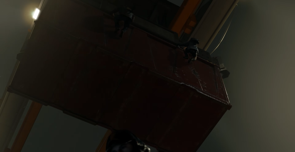 Two workers climbing red shipping container under crane