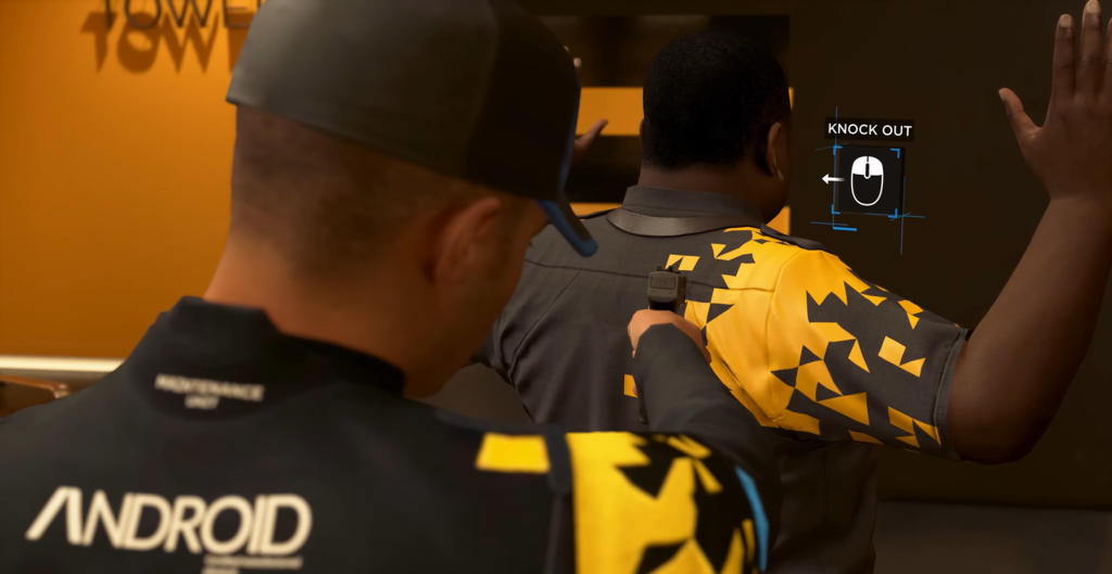 Android points gun at man against wall indoors