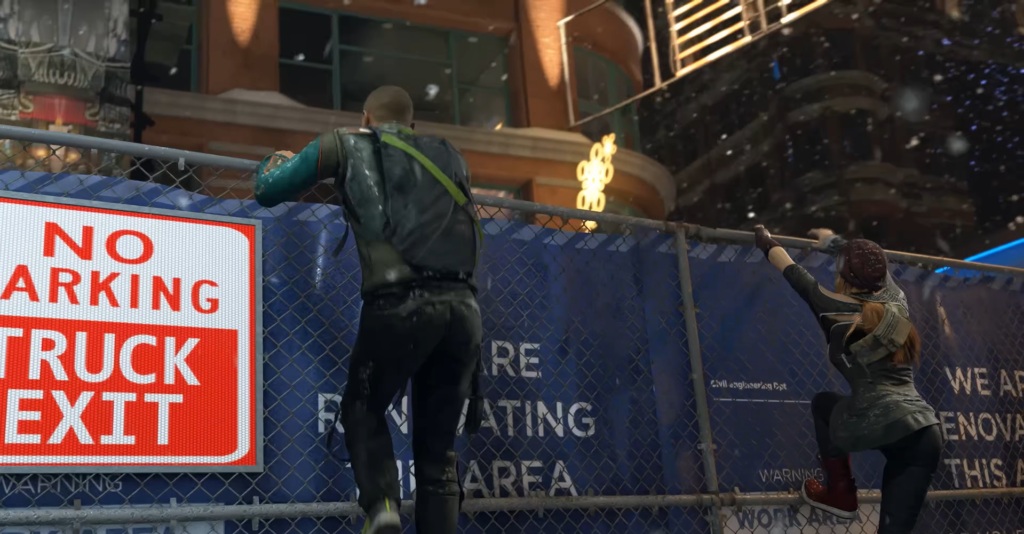 Two people climbing fence at construction site at night