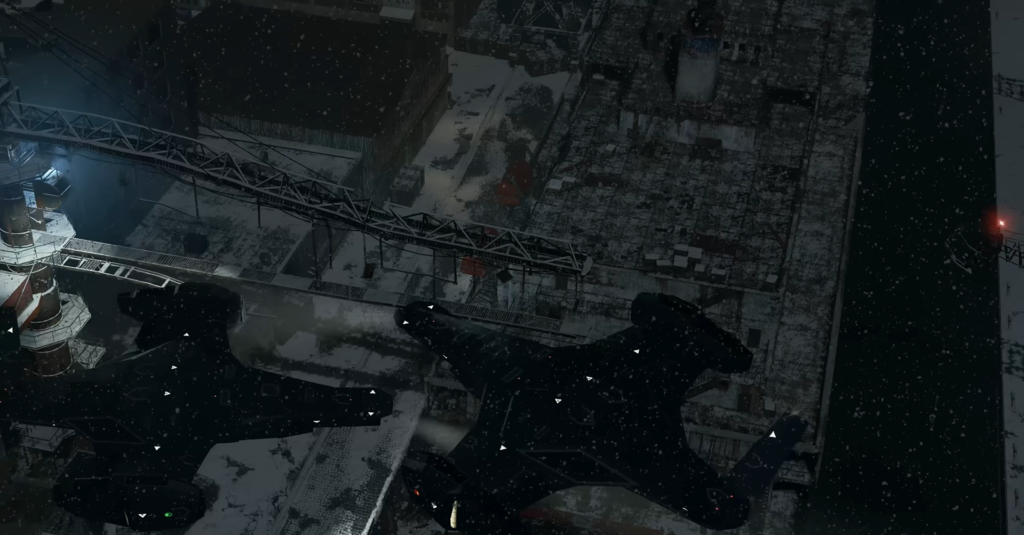 Two helicopters fly over snowy industrial complex at night