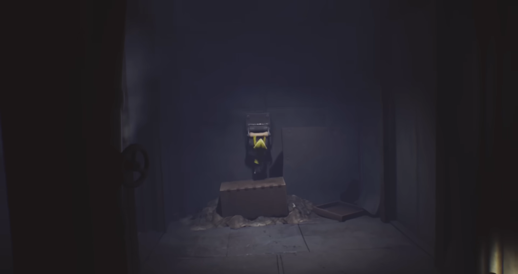 Little Nightmares character climbs suitcase in dark room