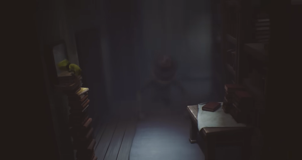 Shadowy figure stands in dim room with books