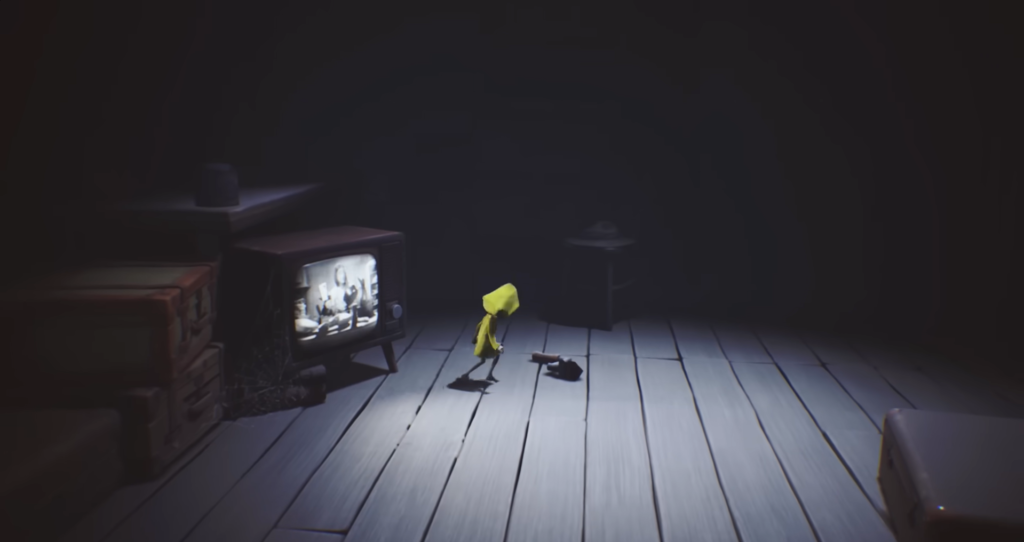 Six from Little Nightmares walks past TV indoors
