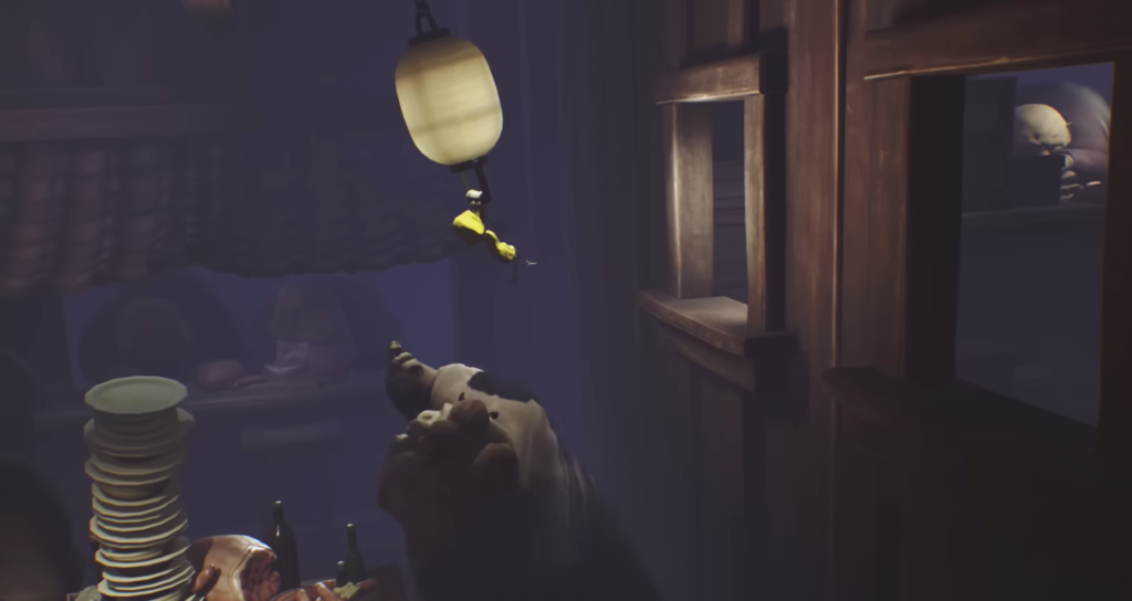 Six from Little Nightmares hangs from lantern in kitchen