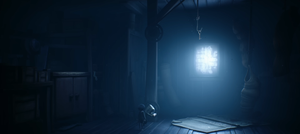 Small hooded figure stands in dark room