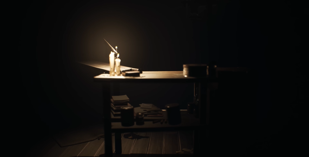 Lit candle on desk in dark room