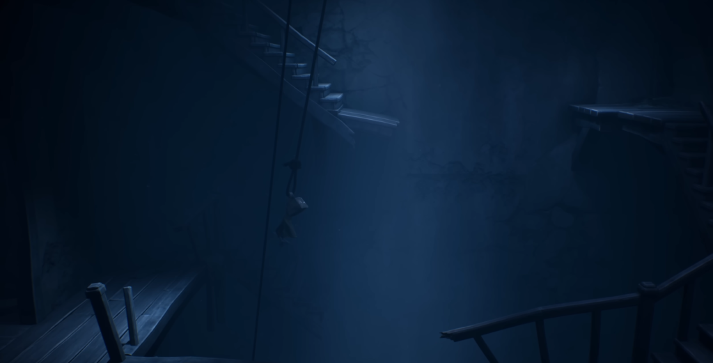 Small figure hanging from rope in dark blue room