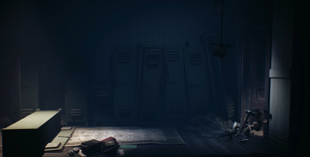 Dim locker room with desk and scattered books