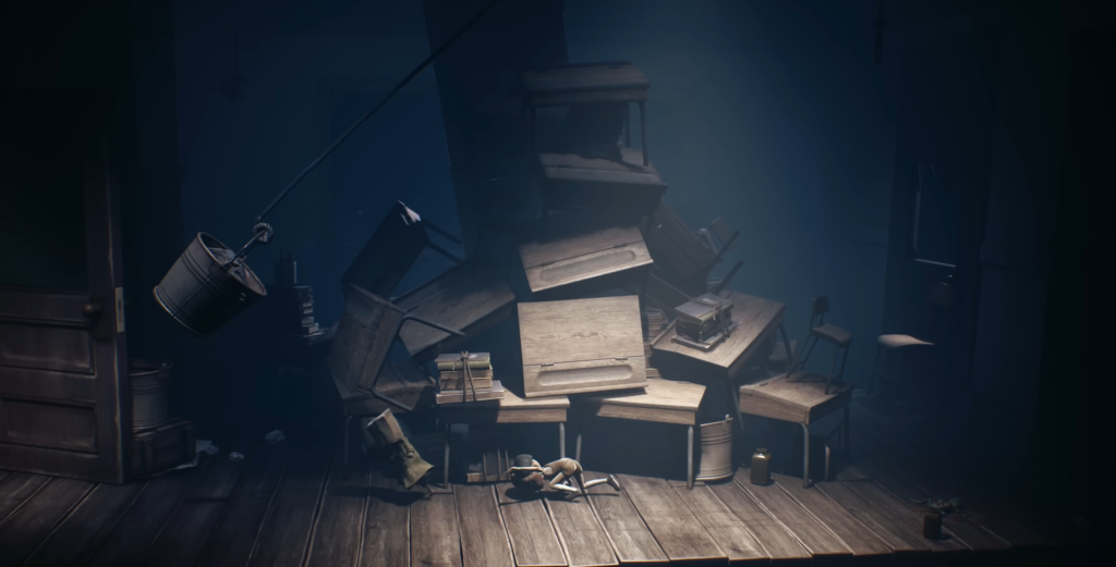 Small figure crawling on wooden floor among stacked furniture