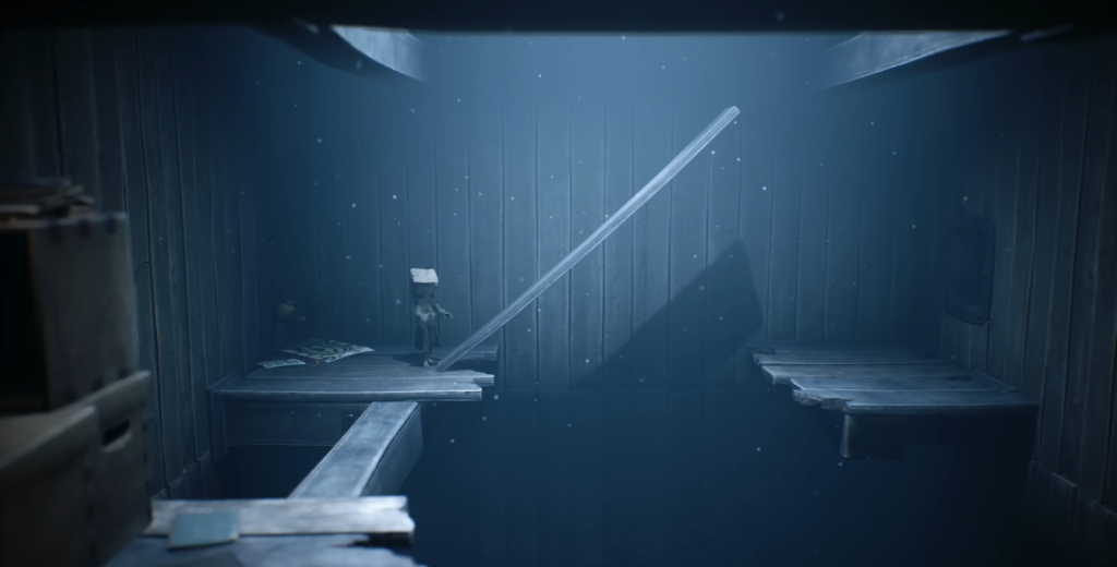Little Nightmares character stands on wooden platform indoors