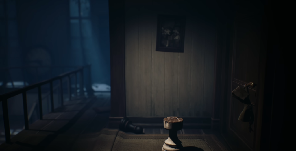 Candle holder on floor in dim hallway