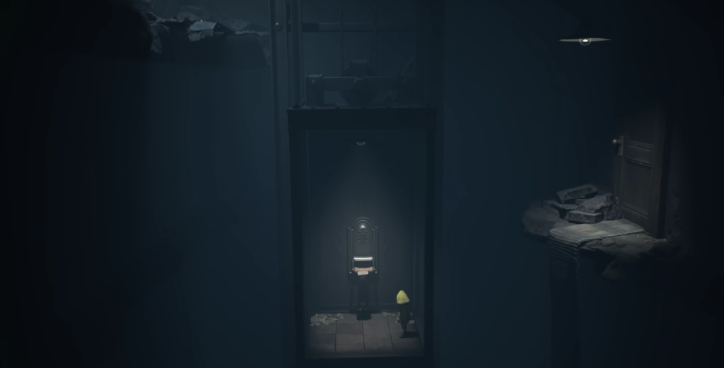 Little Nightmares Six stands beside chair in dark room