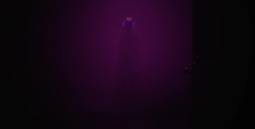 Purple spotlight shining on stage in darkness