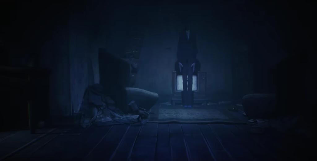 Tall figure stands before glowing TV in dark room