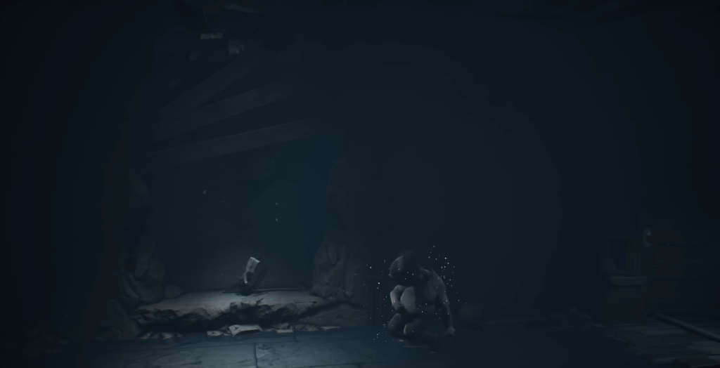 Small figure crouches in dark cave chamber