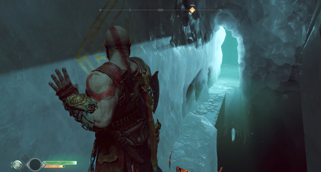 Kratos squeezes through icy cave passage in God of War