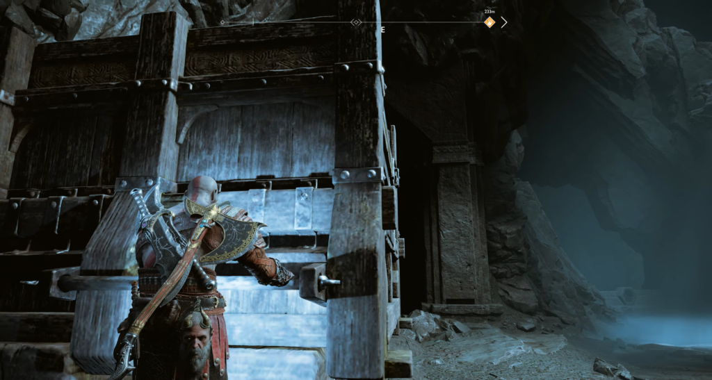 Kratos opens wooden gate in cave, God of War