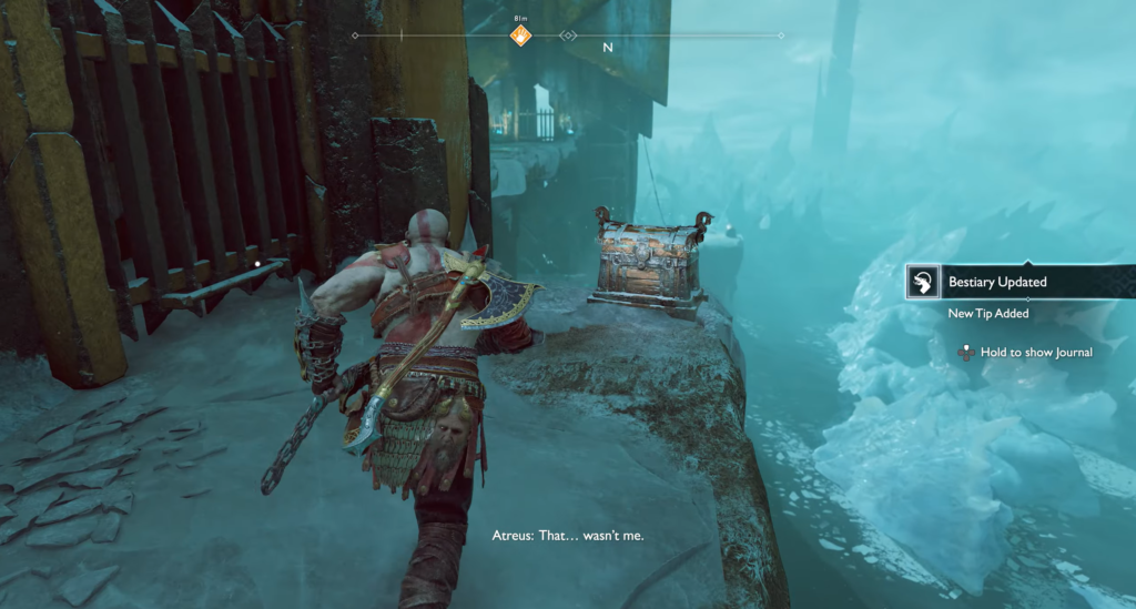 Kratos running toward chest on icy cliff in God of War