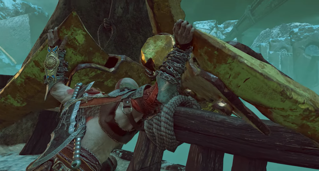 Kratos lifts green metal debris on wooden platform