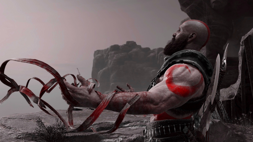 Kratos from God of War holding red ribbons outdoors