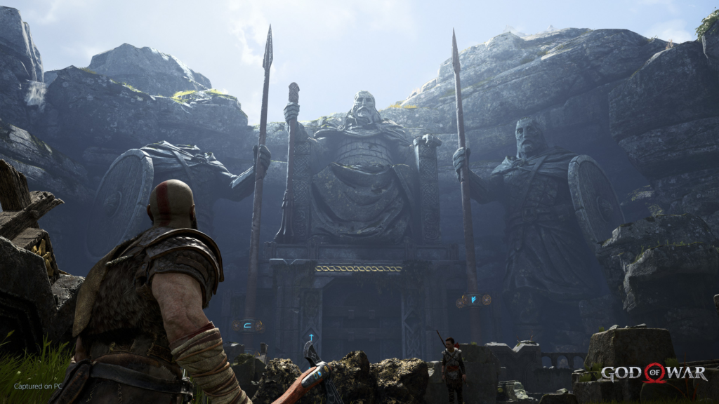 Kratos stands before giant statues in God of War